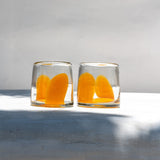 Vaso de vidrio soplado transparente con mancha naranja colección brochazo